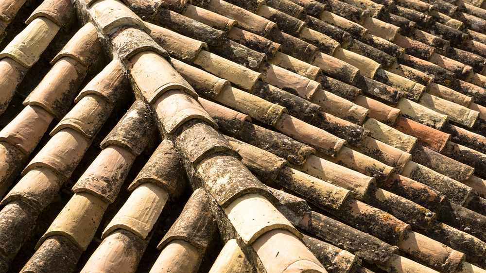 Tuiles de terre cuite formant un toit incliné légèrement usées Tuiles de terre cuite formant un toit incliné légèrement usées